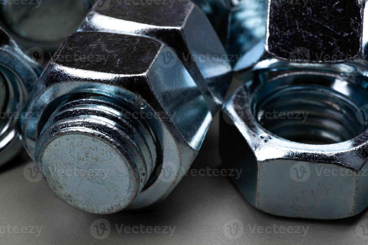 steel nuts, screwed on a bolt closeup photo