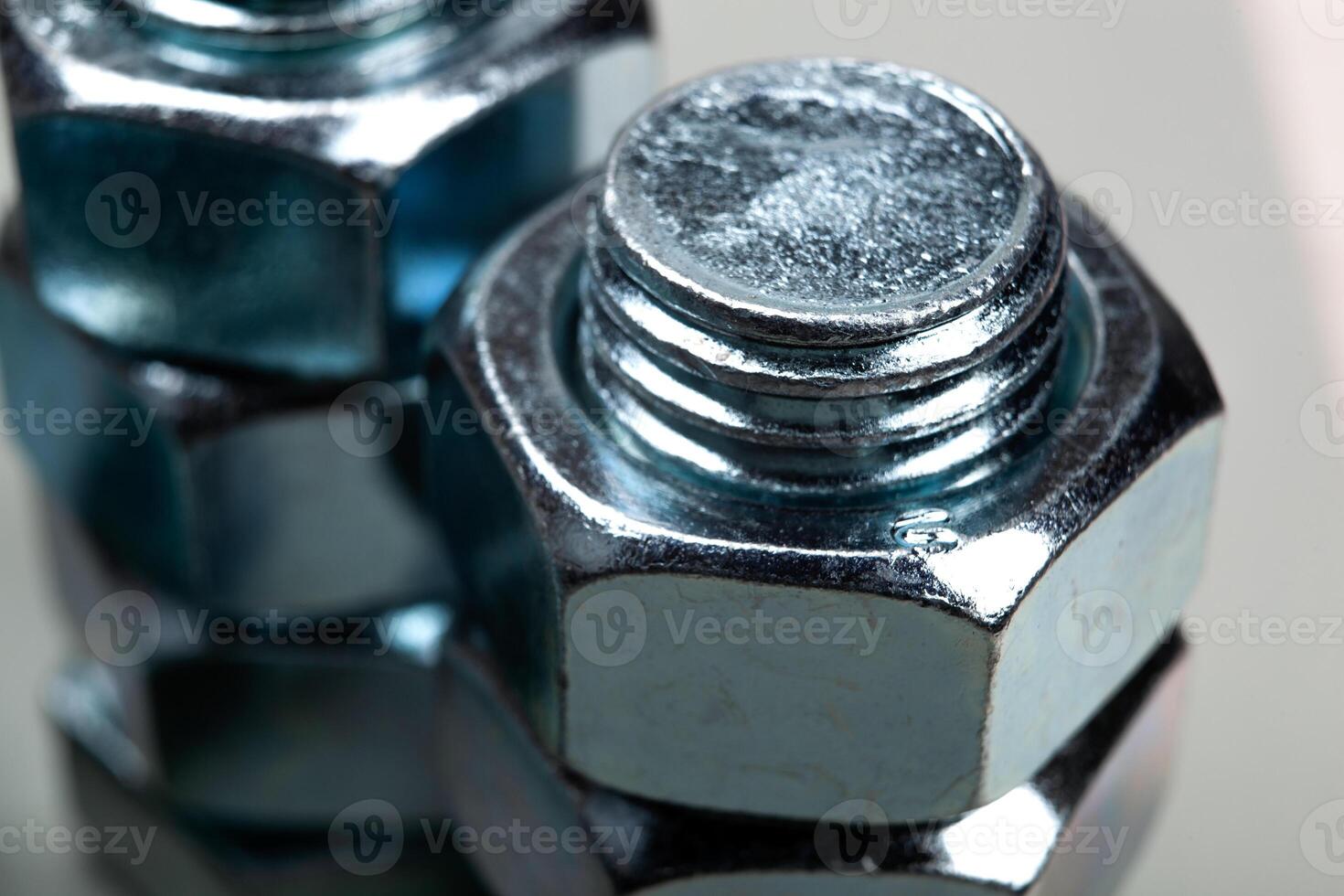 steel nuts, screwed on a bolt closeup photo