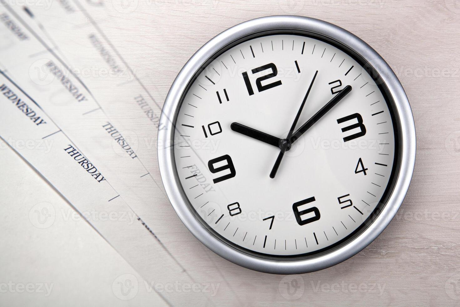 large white clock face with calendar sheets photo