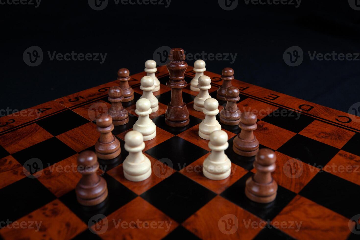 chess pawns and king on a board on a black background photo