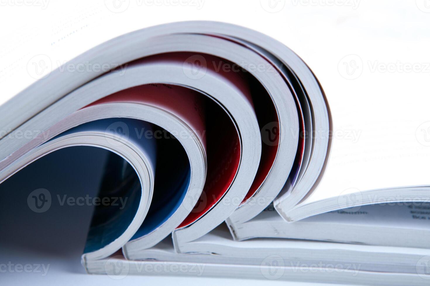 stack of open glossy magazines on white background photo