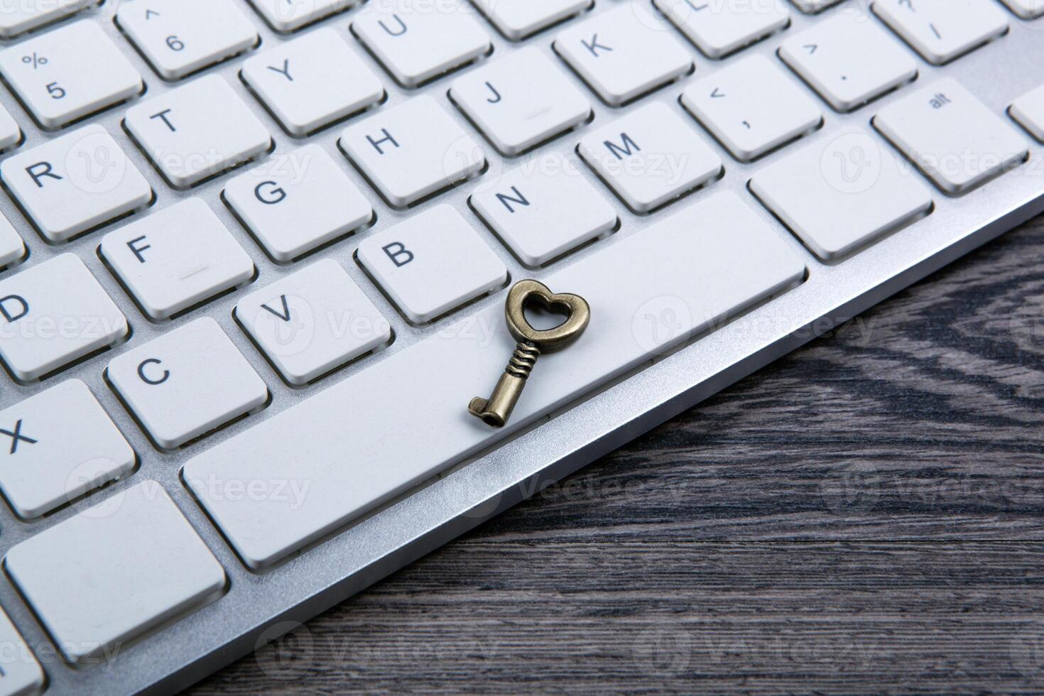 little key on computer keyboard as concept protection closeup photo