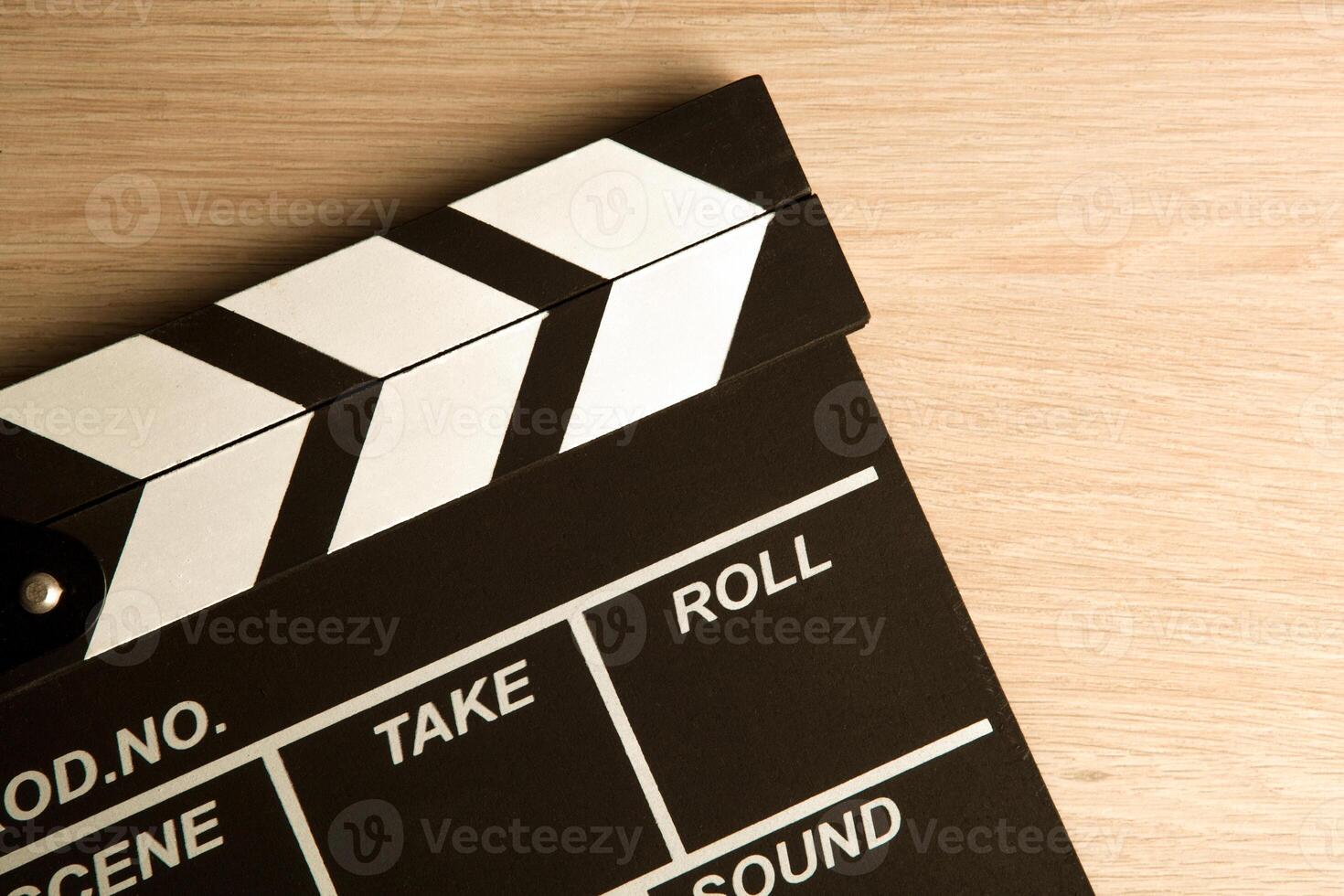 black movie clapper on a wooden background top view photo