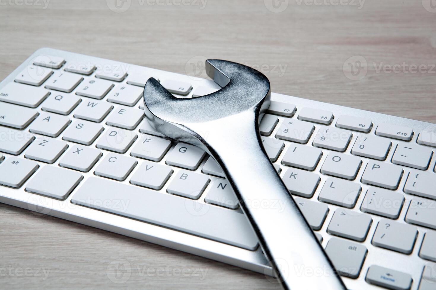 big wrench and a computer keyboard close up photo