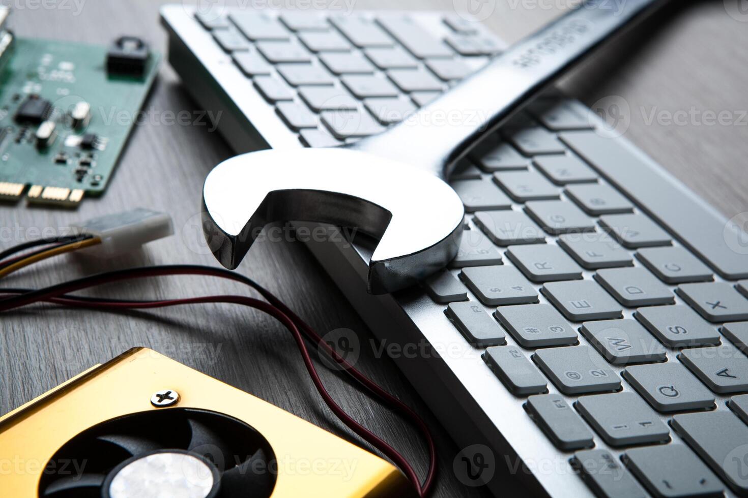 big wrench and a computer keyboard and computer parts photo
