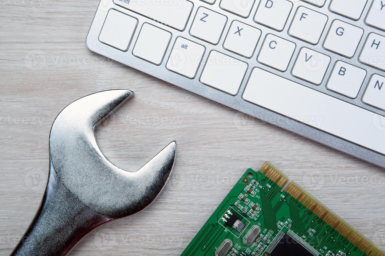 big wrench and a computer keyboard and computer parts photo