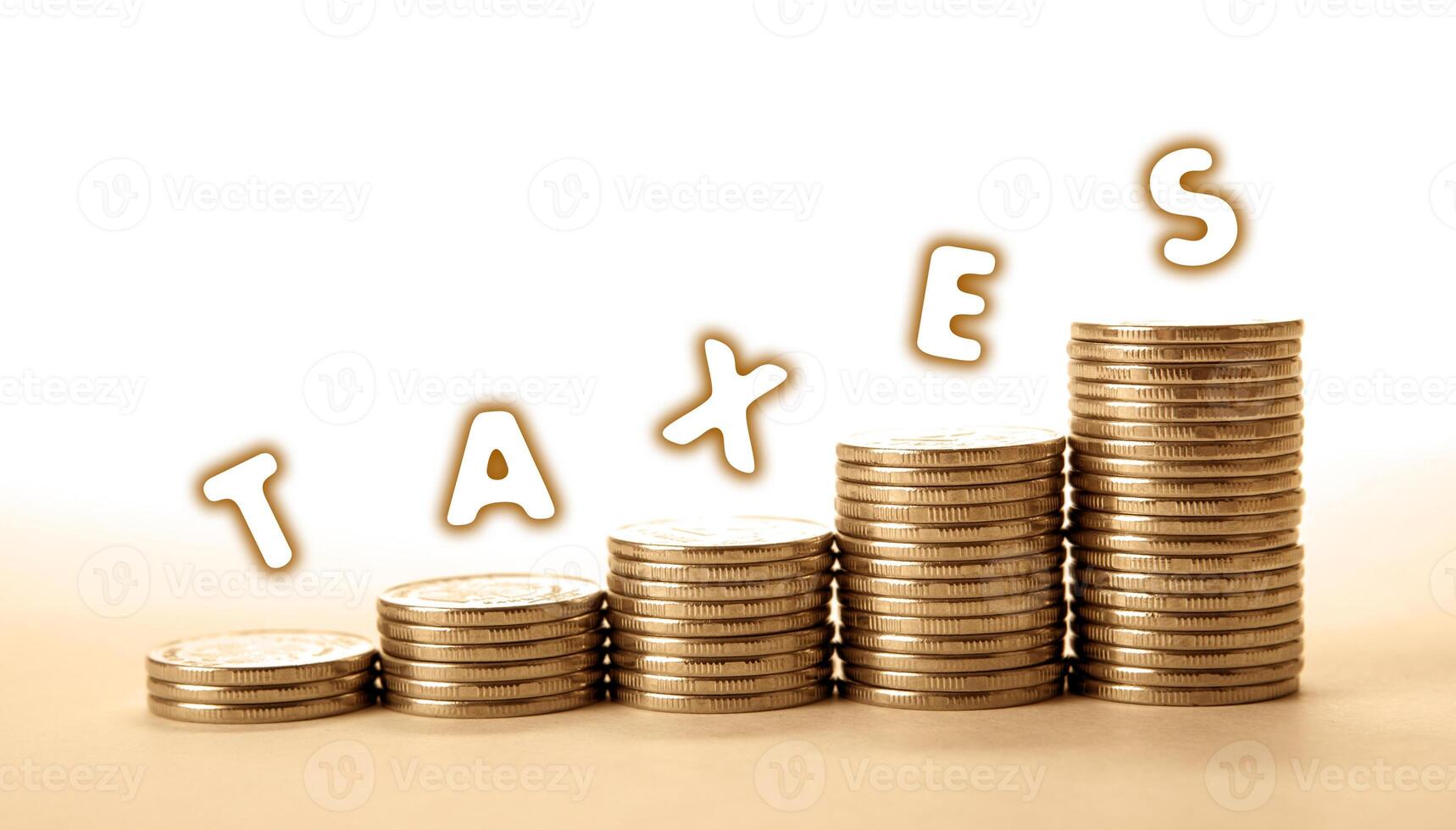 stacks of coins on a white background with inscription taxes photo