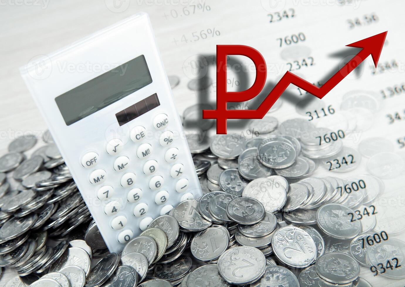 white calculator with russian ruble coins and a symbol of the growing ruble photo