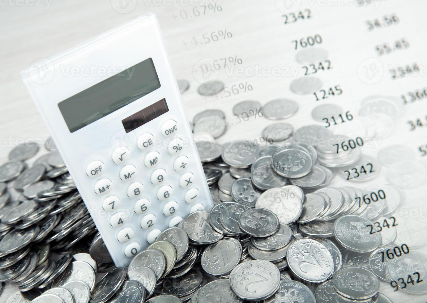 white calculator with russian ruble coins and digits photo