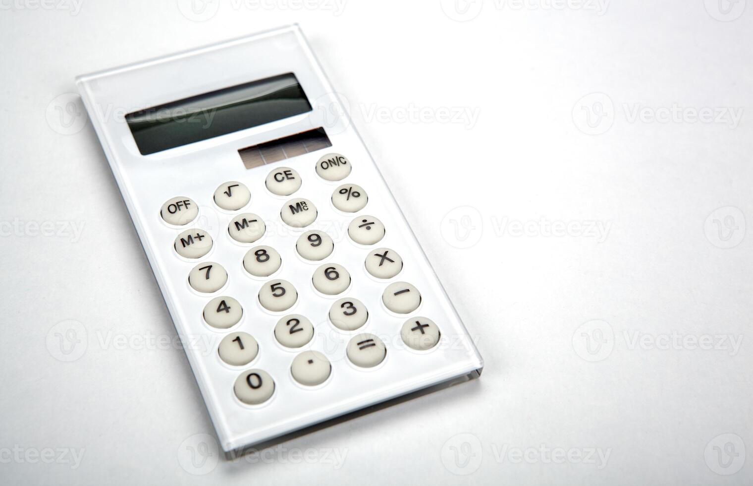 white business calculator on a white desktop photo