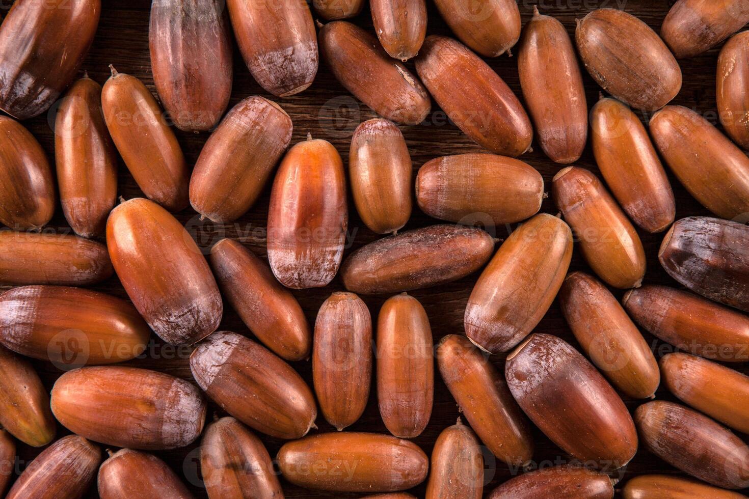 ripe acorns of oak on a wooden background photo