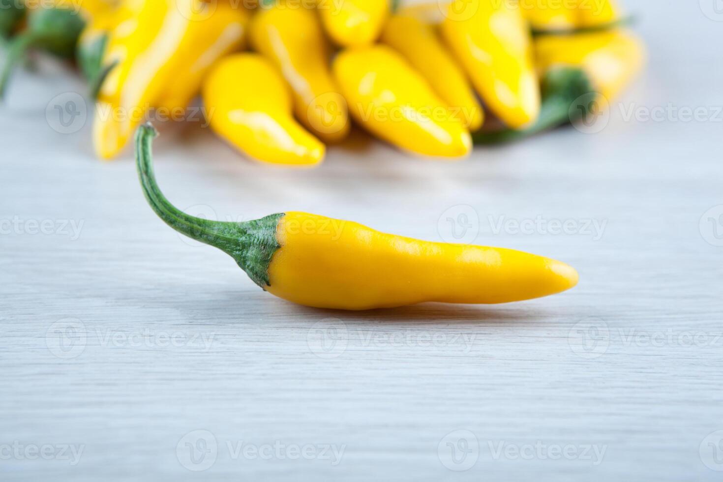 the one fruit of yellow fresh chilli pepper against the rest of the peppers photo