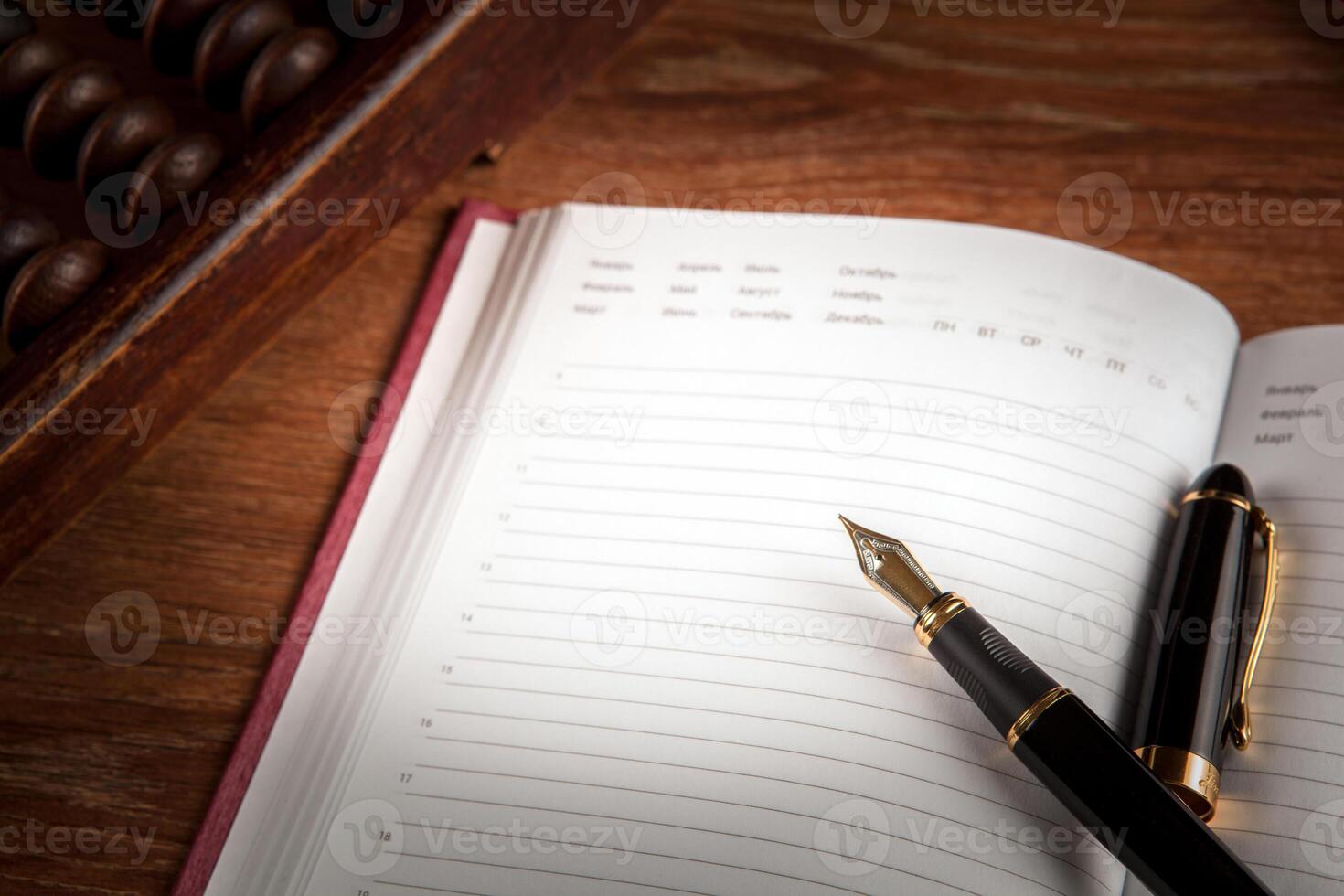 fountain pen and diary on a table with an abacus photo