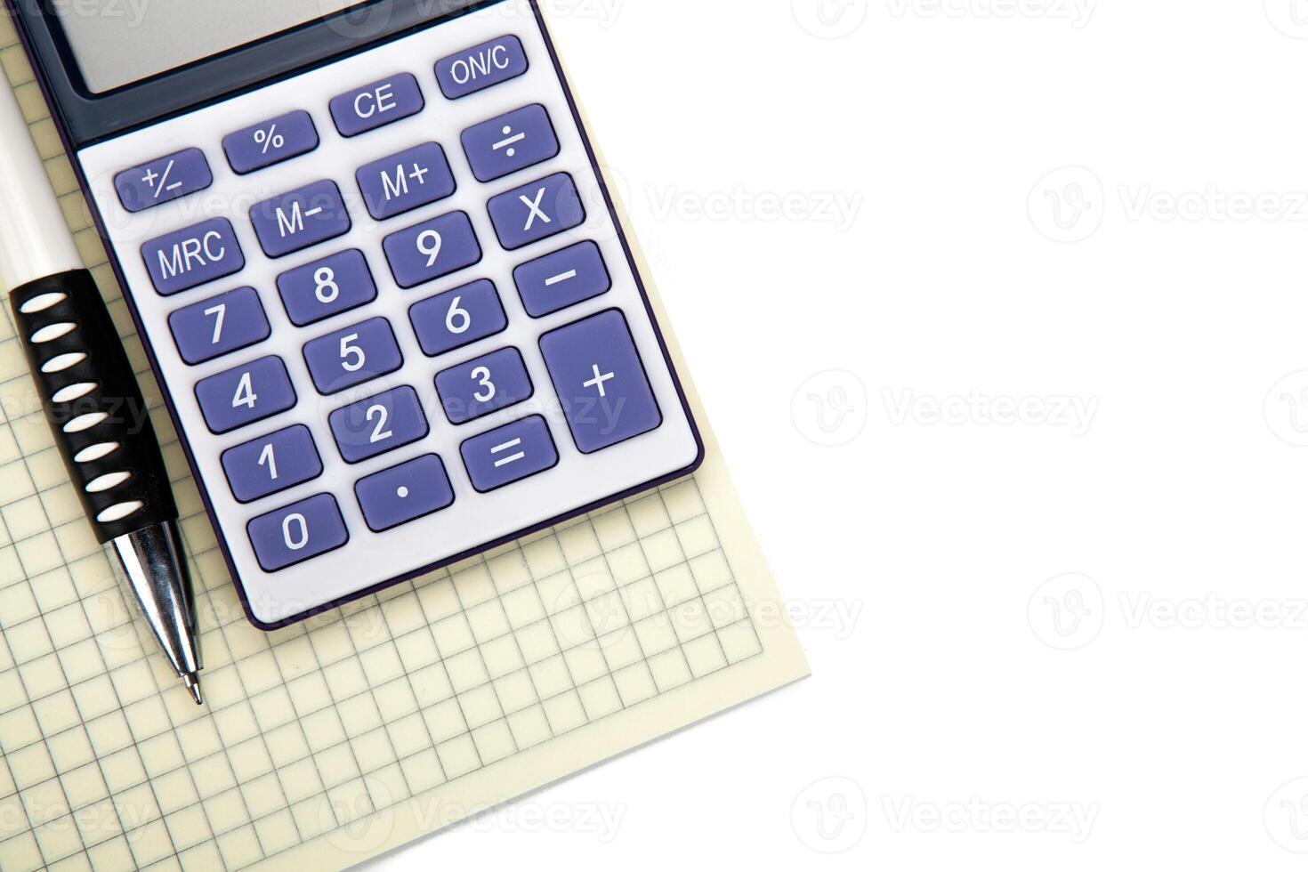 One big calculator with yellow checkbook and stationery on a white table photo