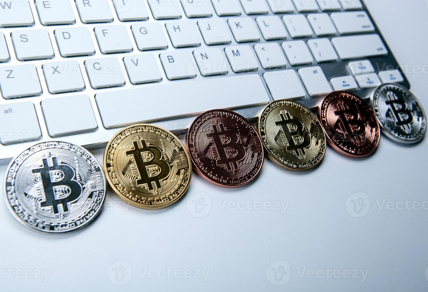 six coins of bitcoin on white laptop pc keyboard photo