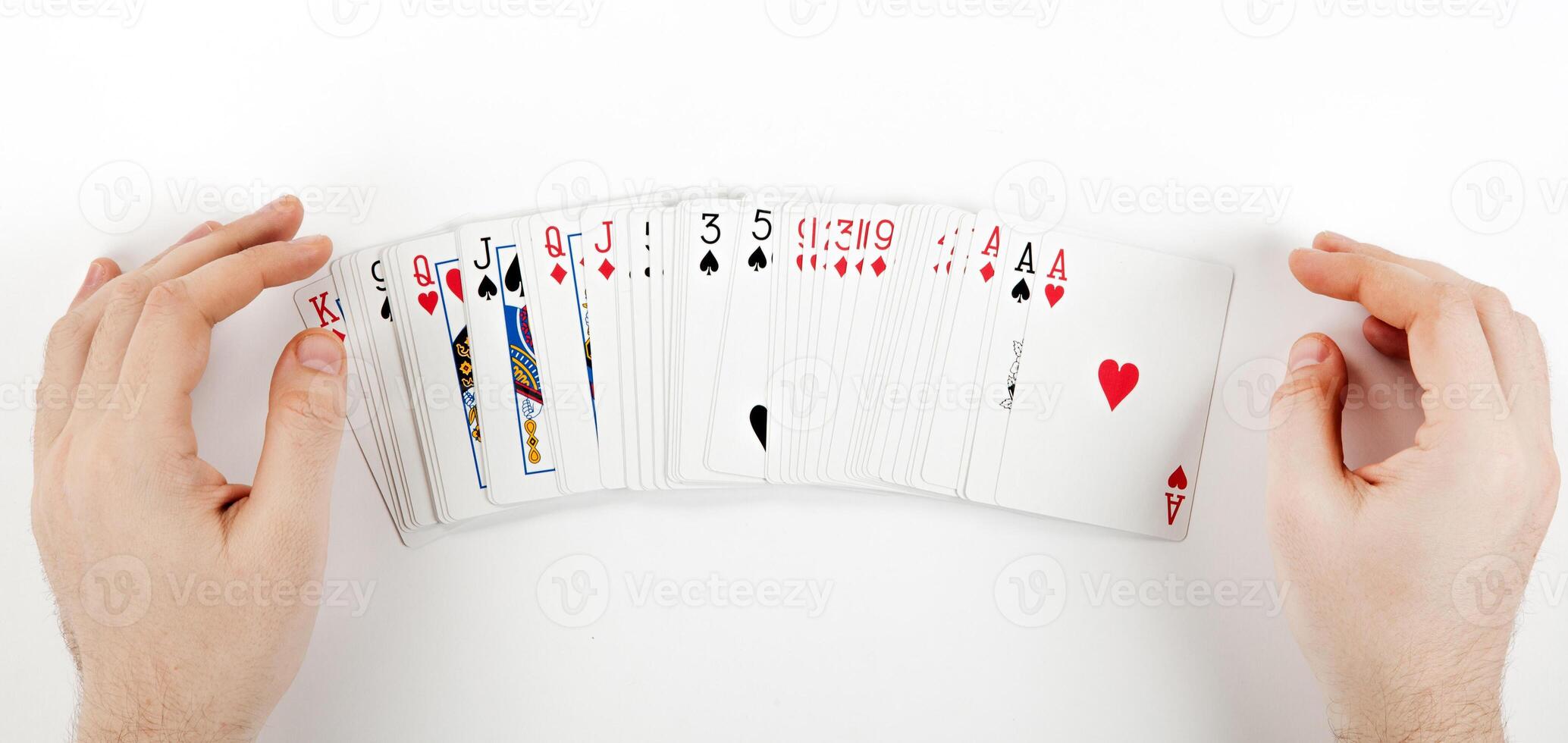 Big deck of cards in the form of a fan on the table and the player's hands photo