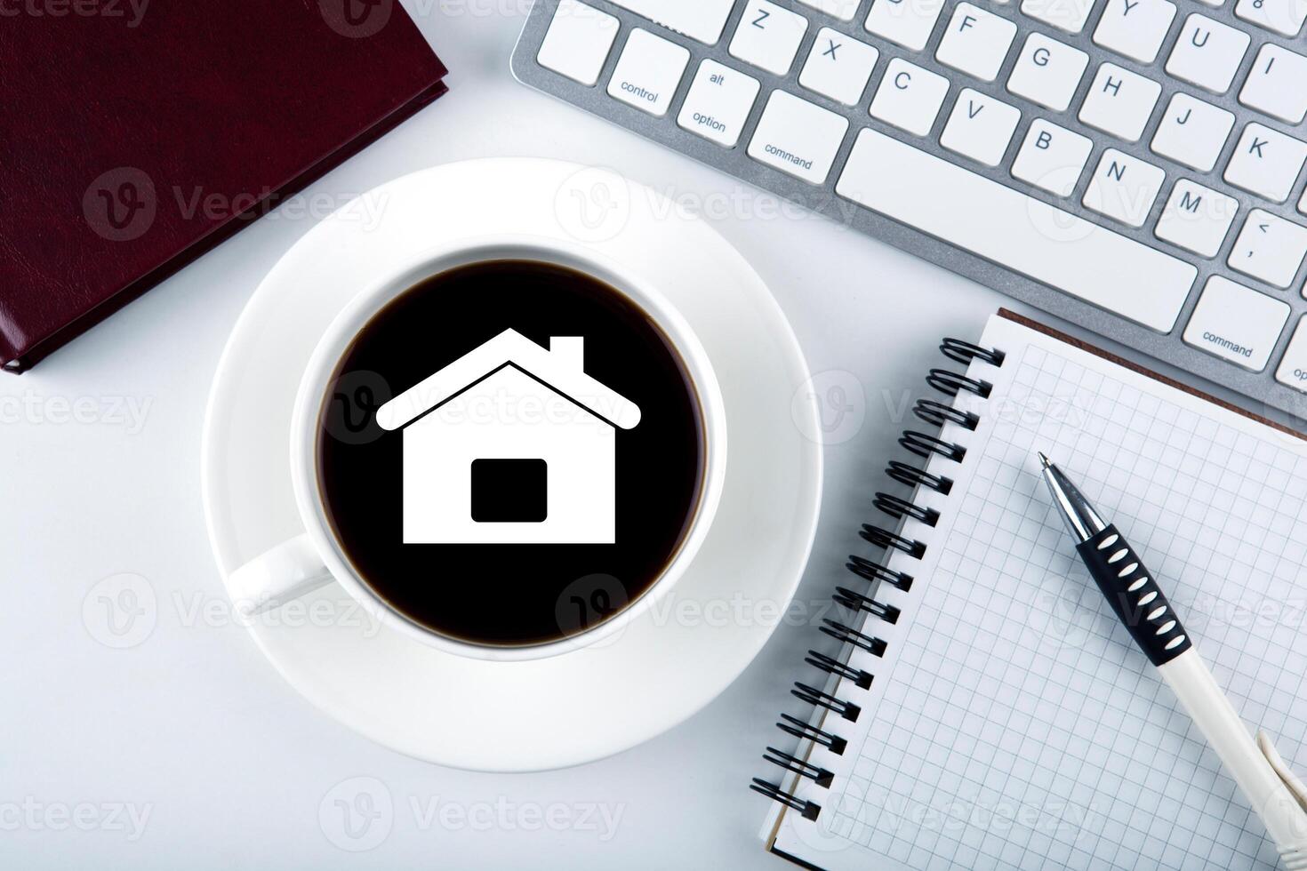 symbol of the house and a cup of coffee with keyboard and diary photo