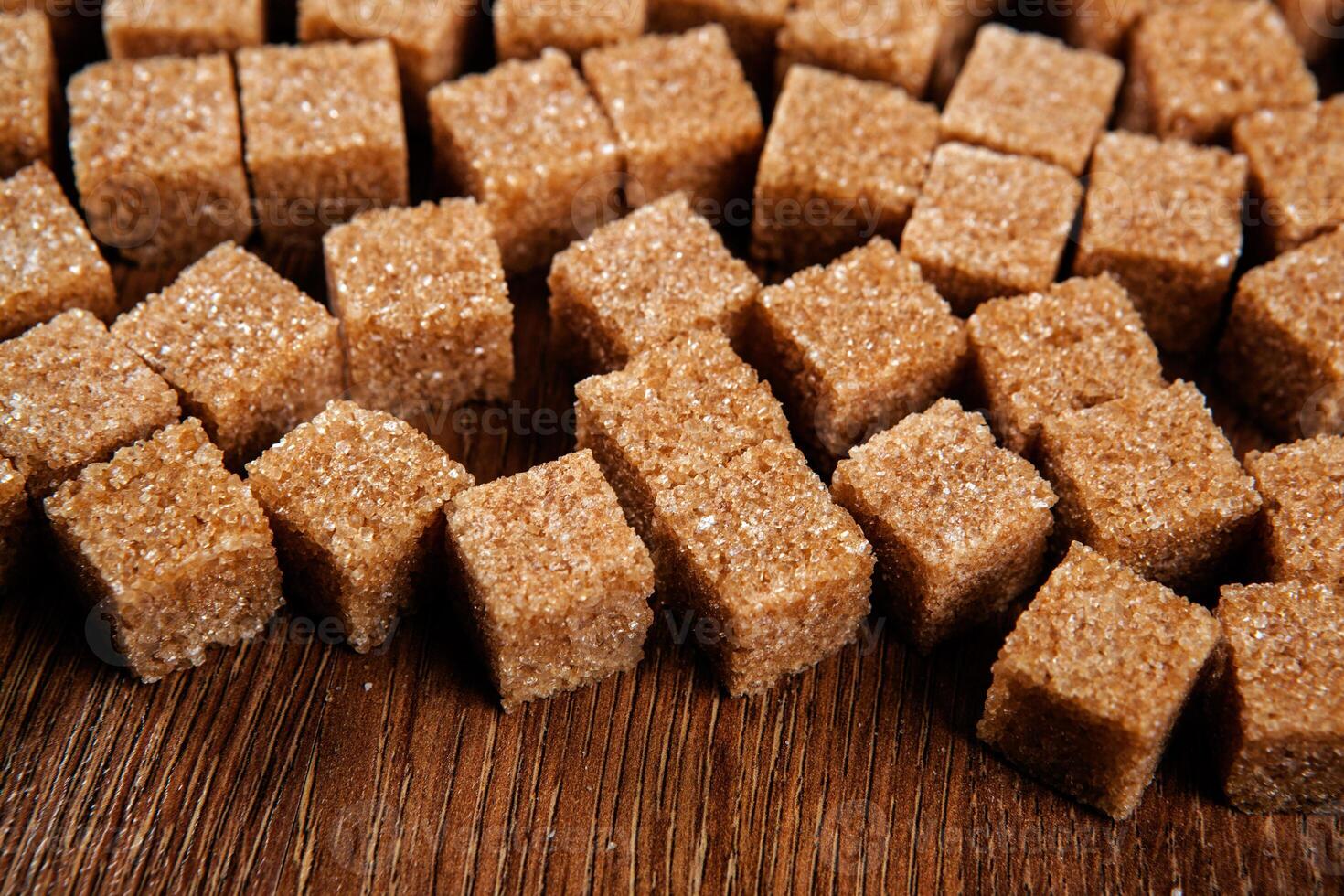 background of cubes of brown sugar on a wooden table photo