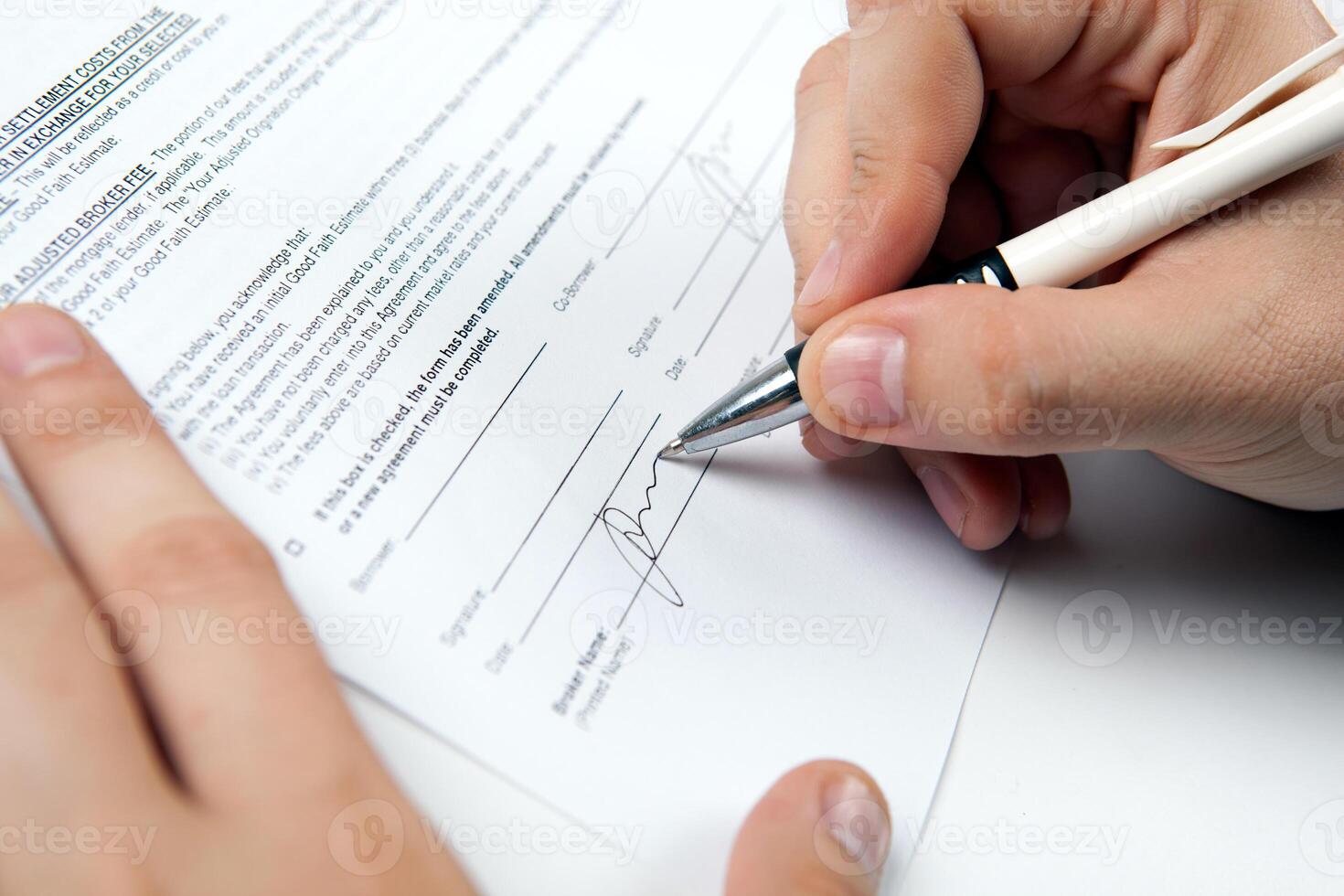 the man's hand signs the document and the signature photo