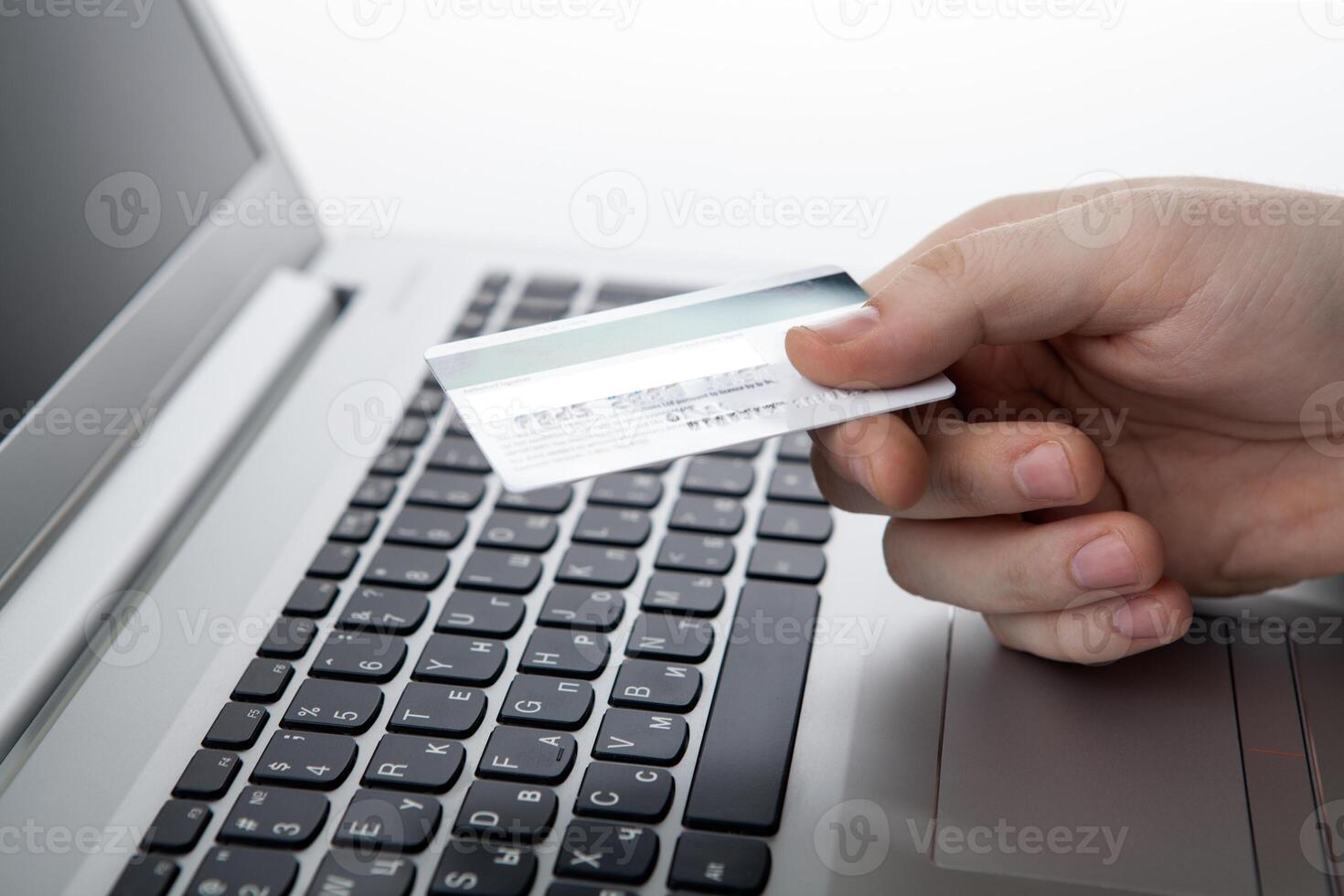 Hands holding a credit card and using laptop computer photo