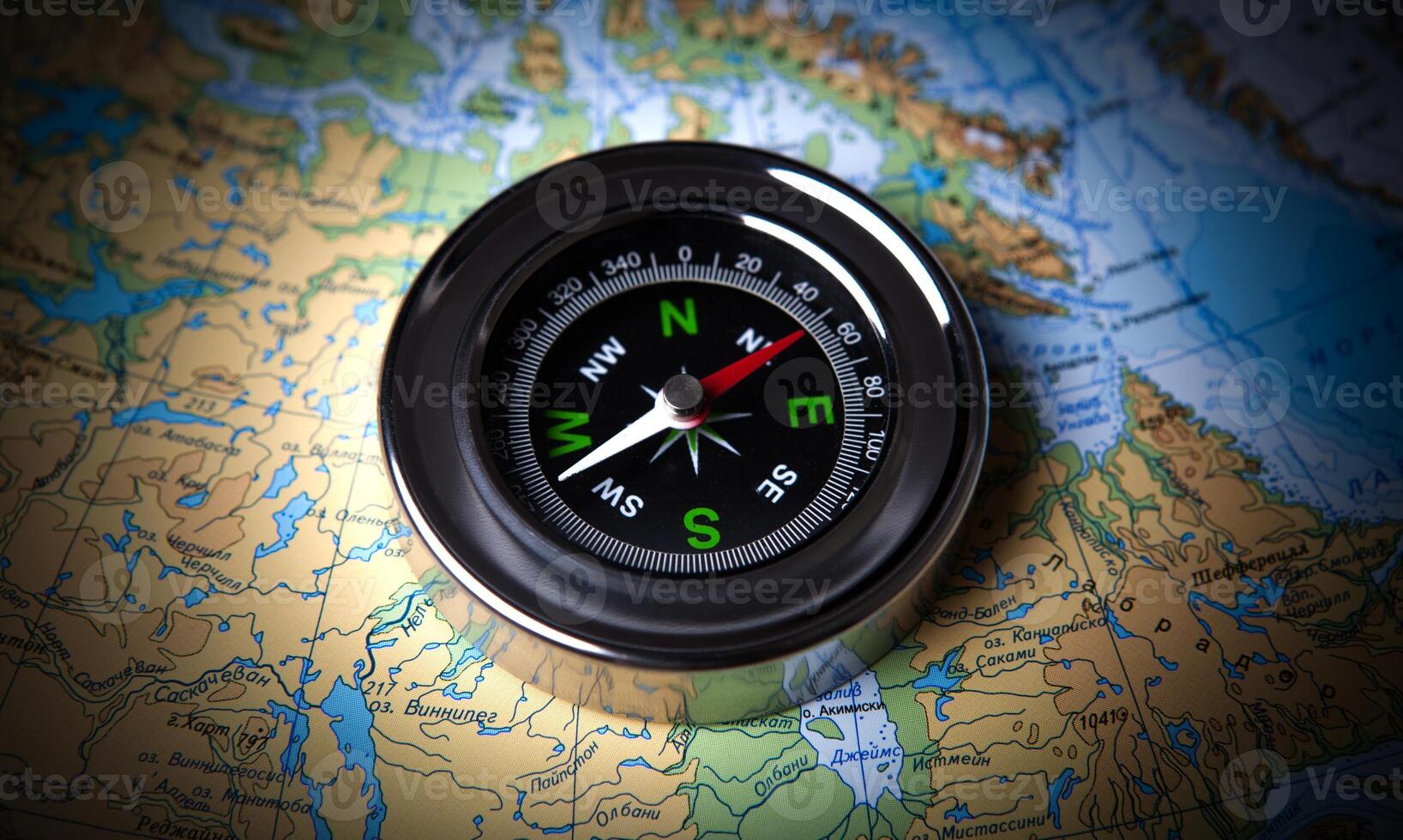 tourist compass lying on a map photo