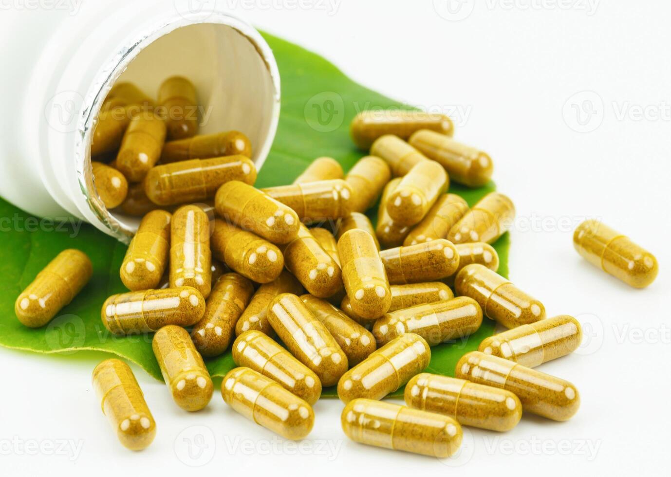 Turmeric Powder in Transparency Hard Gelatin Capsules with Green Natural Leaves on White Background. photo