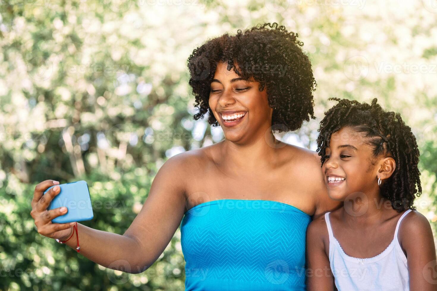portrait of a single mother with her daughter watching her phone or making a call. photo