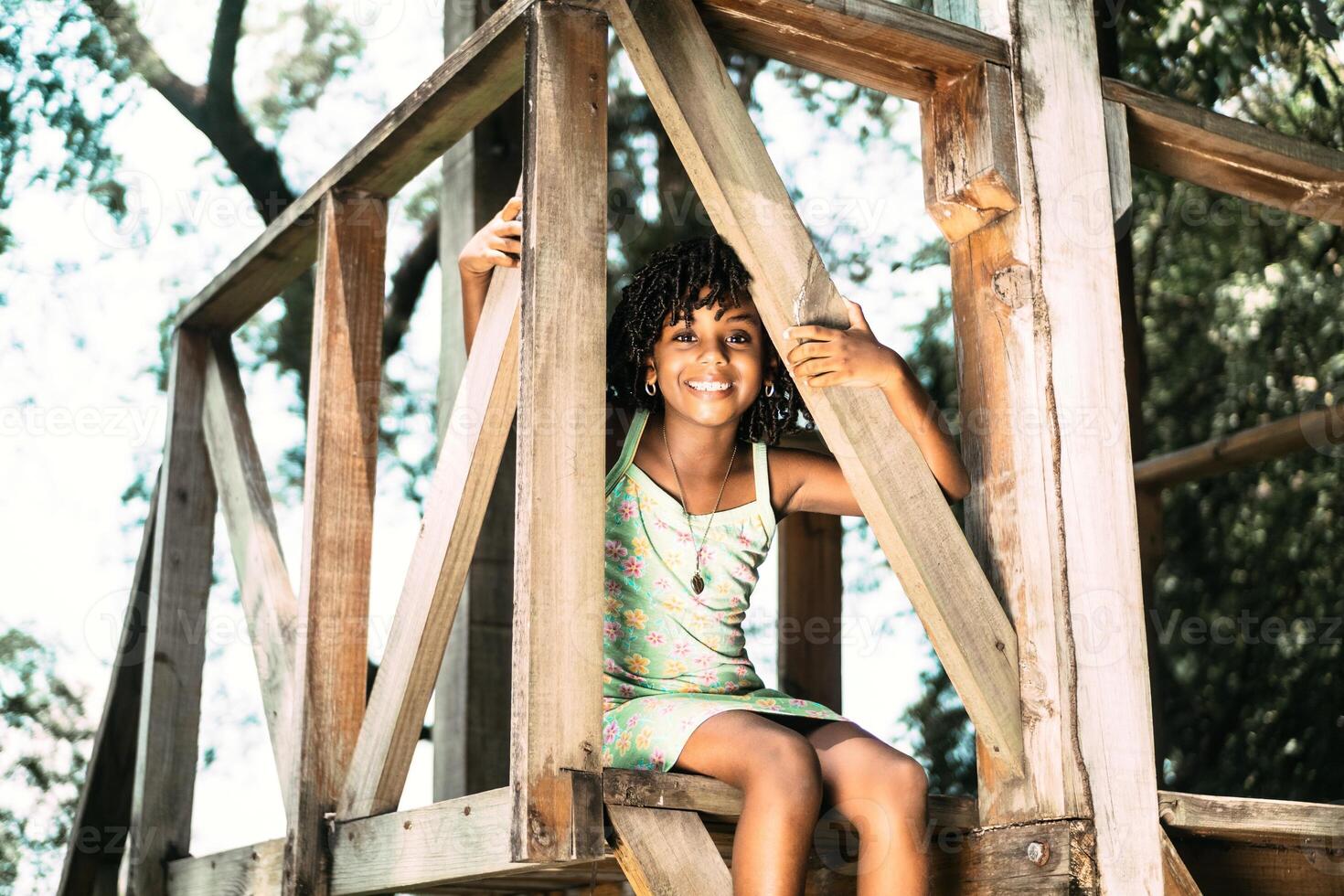 portrait of a small afro american girl sitting looking at the camera. photo