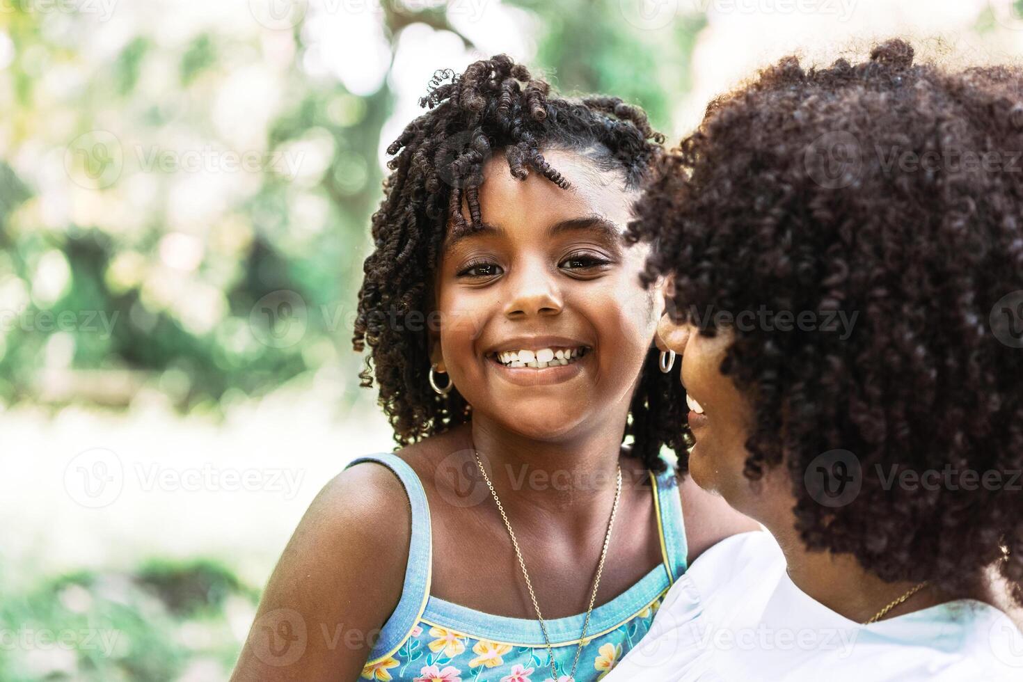 portrait of a little afro american girl looking at the camera smiling and happy. photo