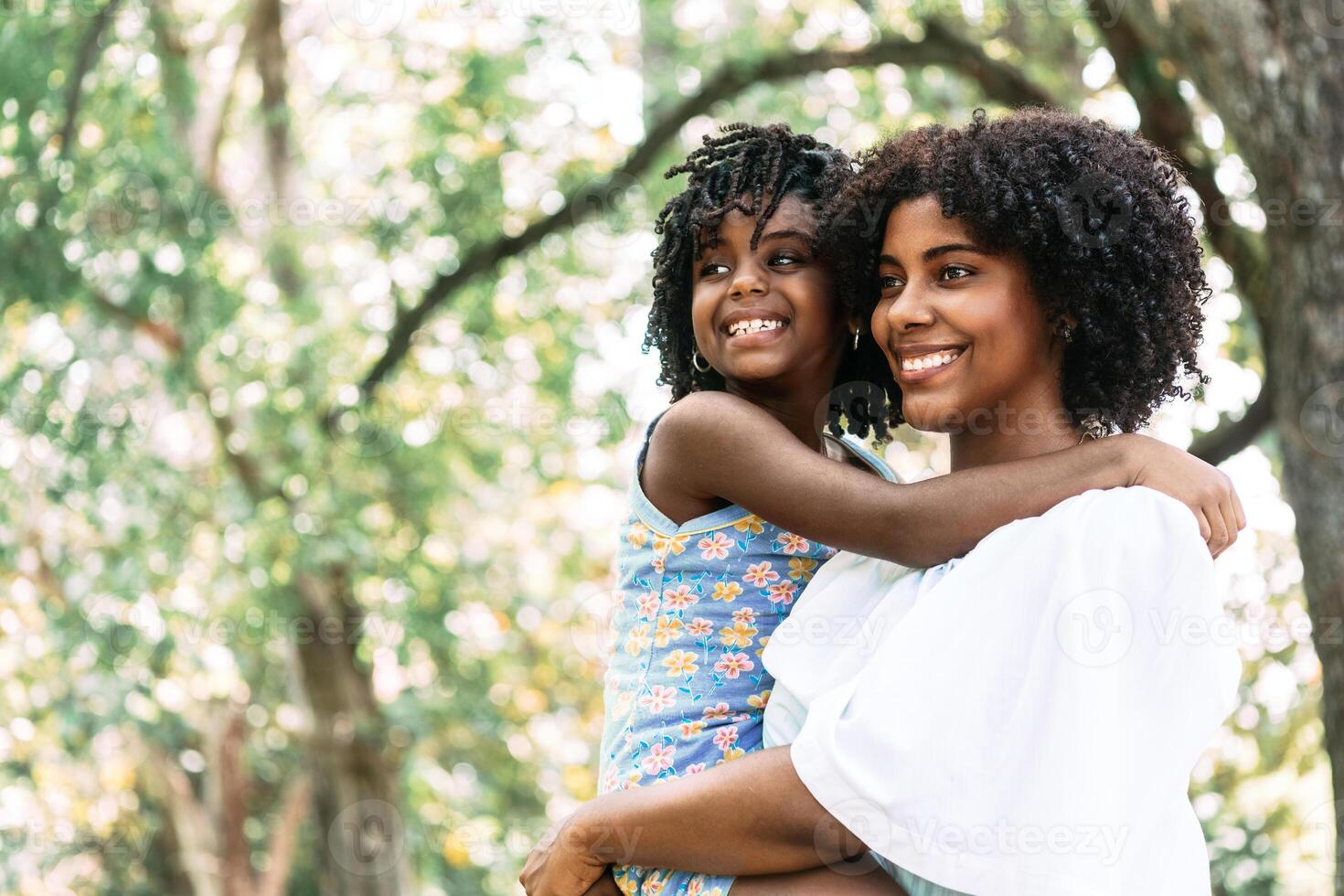 portrait of an african american mother holding a little daughter smiling and happy. photo