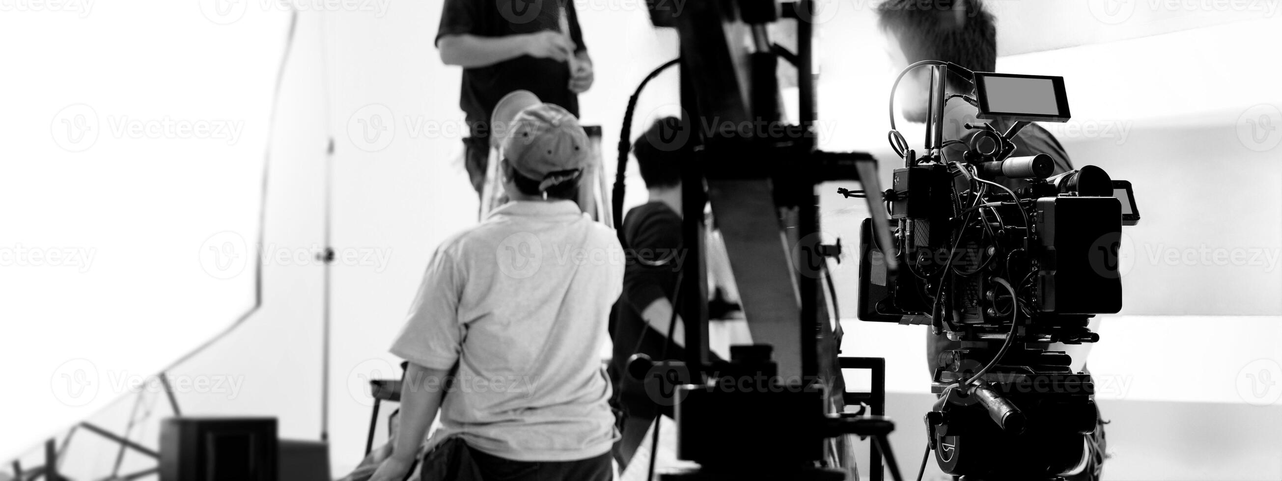 Filmmaker crew team with professional cinema equipment and film camera on the set. Film director and crew making commercial content advertising in studio. Technique of modern filming and advertising. photo
