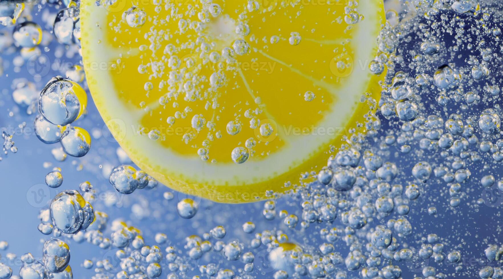 Underwater lemon slice in soda water or lemonade with bubbles. photo
