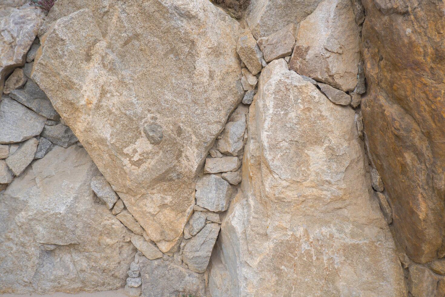 The walls are made of large stones and cobblestones. Stone background. photo