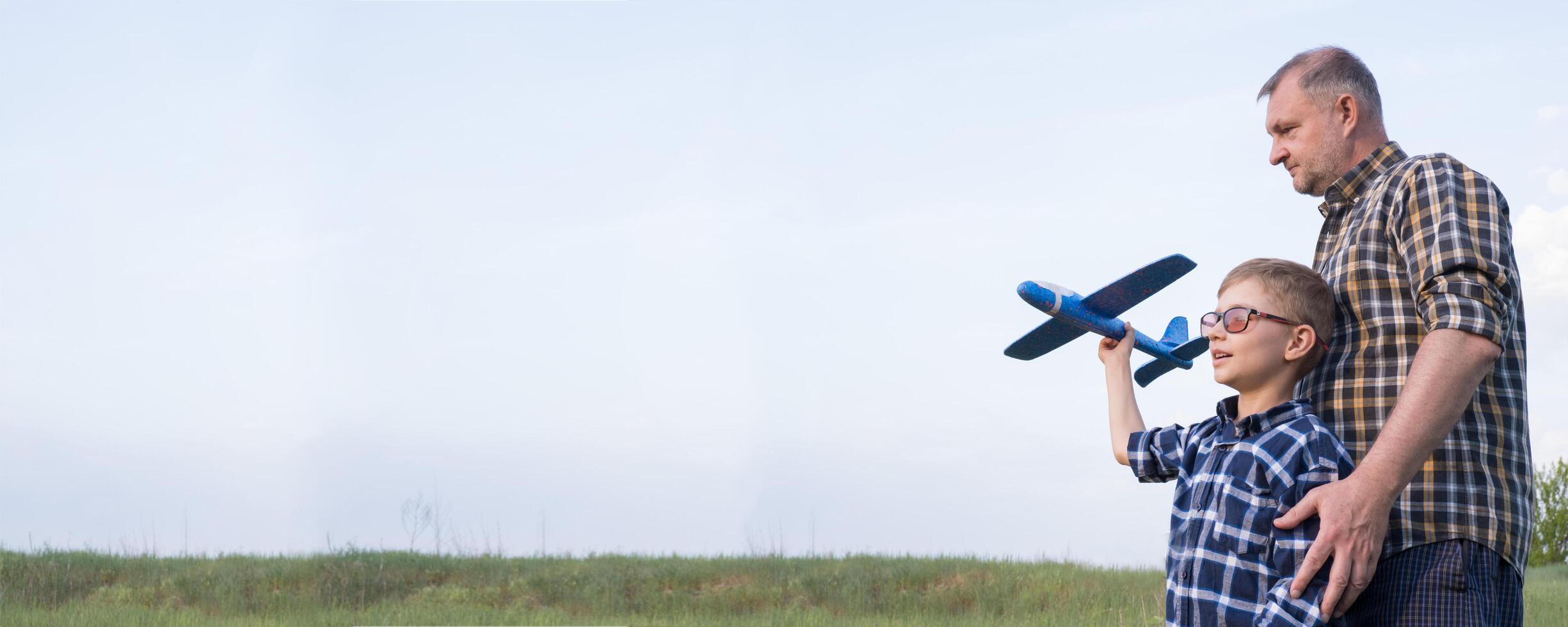 Banner father and son in a field with an airplane. Father's day concept. photo