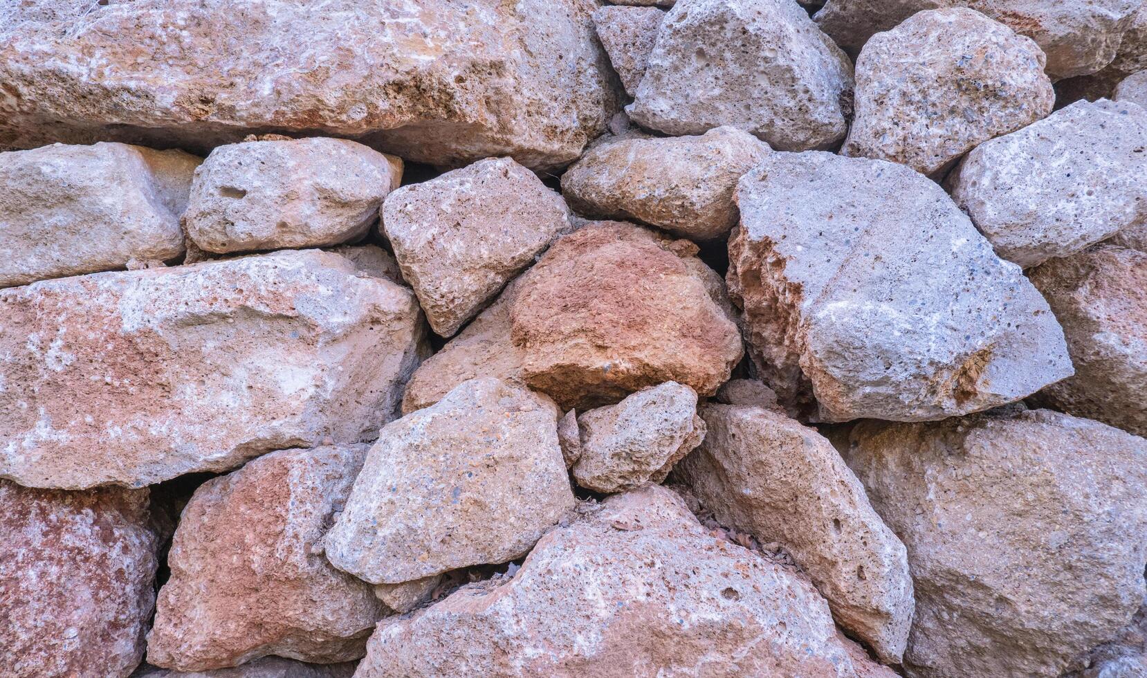 Texture of a stone wall. Old castle stone wall texture background. Brown, sienna large stones. Part of a stone wall, for background or texture. photo