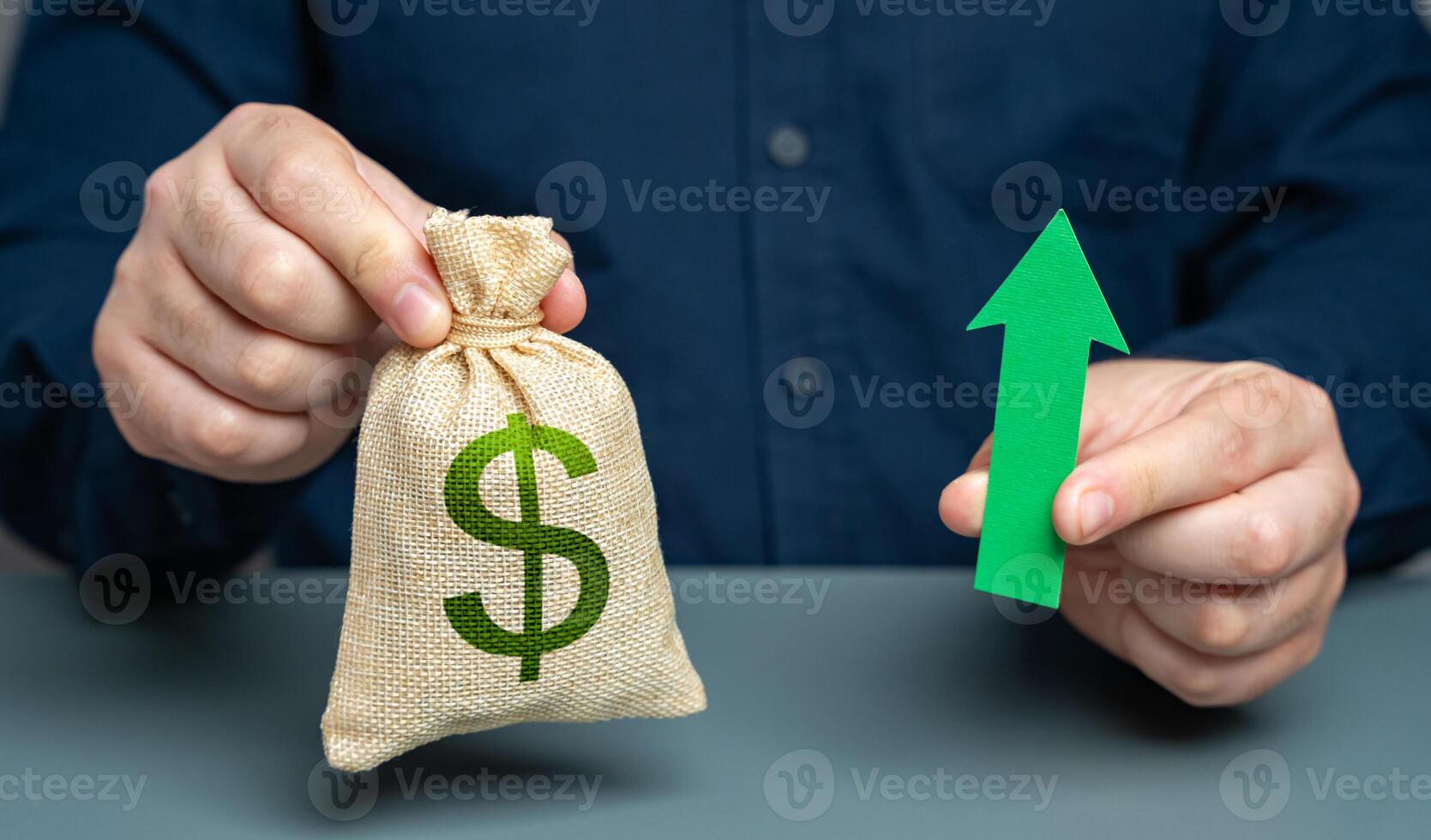 Man holding dollar money bag and green arrow pointing up, concept. Increase in profits and income. Salaries and benefits. Bigger budget, growth of financial resources. Money supply growth. photo