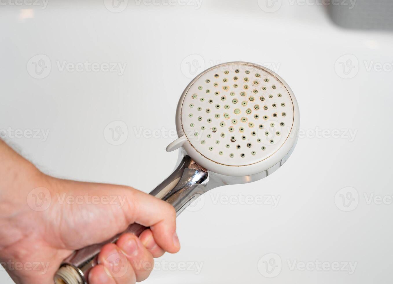 Old shower head. Limescale water stone buildup. Replacement and maintenance of plumbing fixtures. Poor water quality. Mold and bad smell of water. photo
