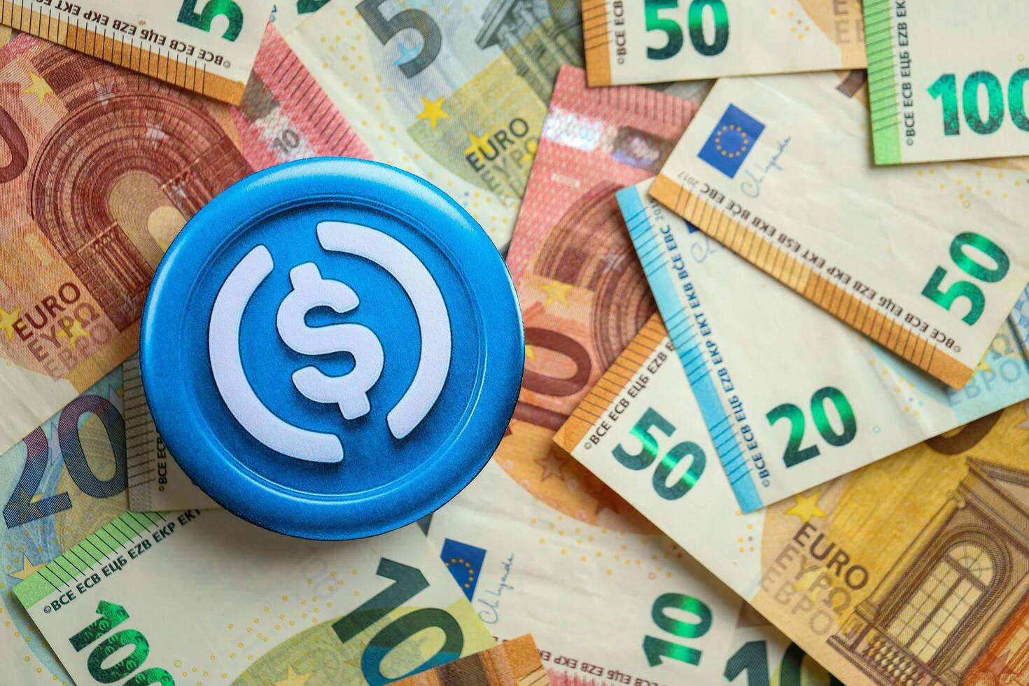 KYIV, UKRAINE - AUGUST 17, 2024 USDC stable coin with big amount of european euro bills photo