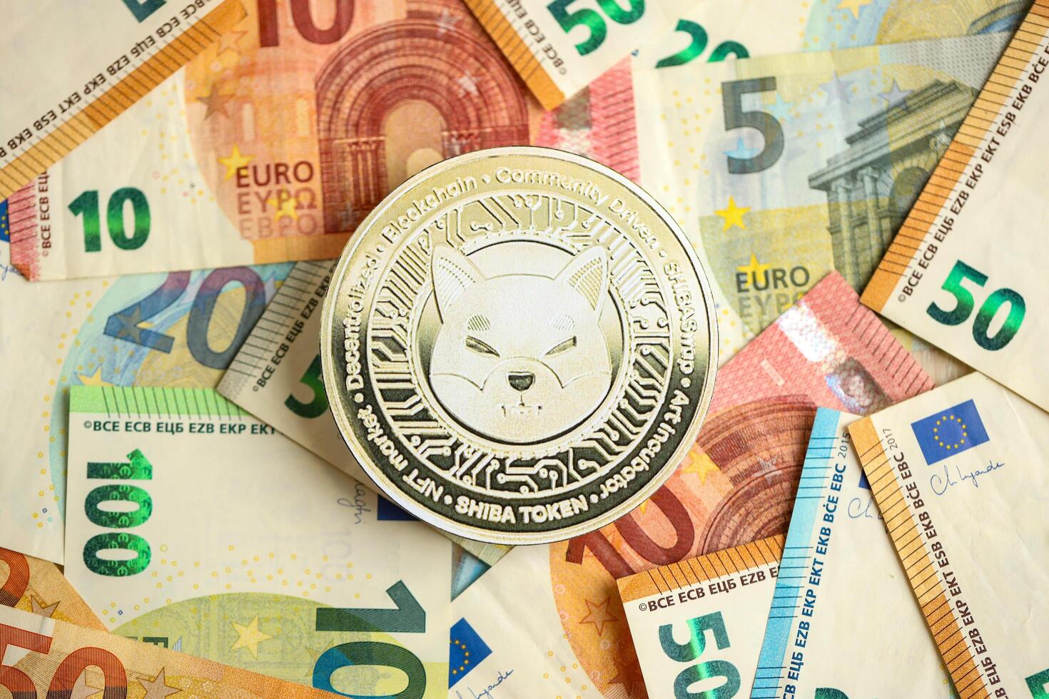 KYIV, UKRAINE - AUGUST 17, 2024 Shiba coin with big amount of european euro bills photo