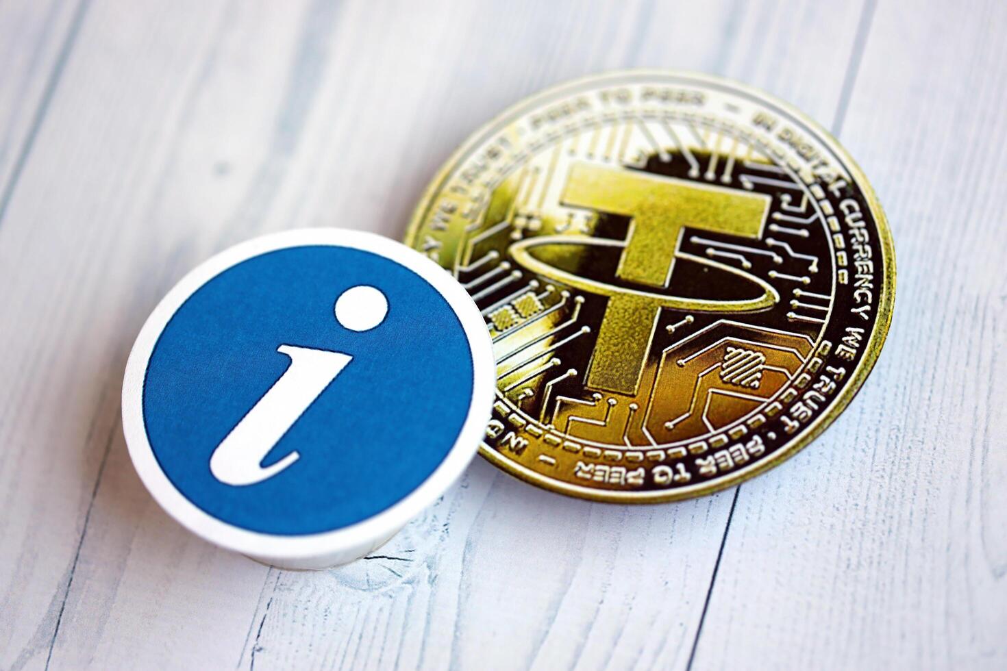 KYIV, UKRAINE - AUGUST 17, 2024 Tether USDT coin and information sign on wooden background photo