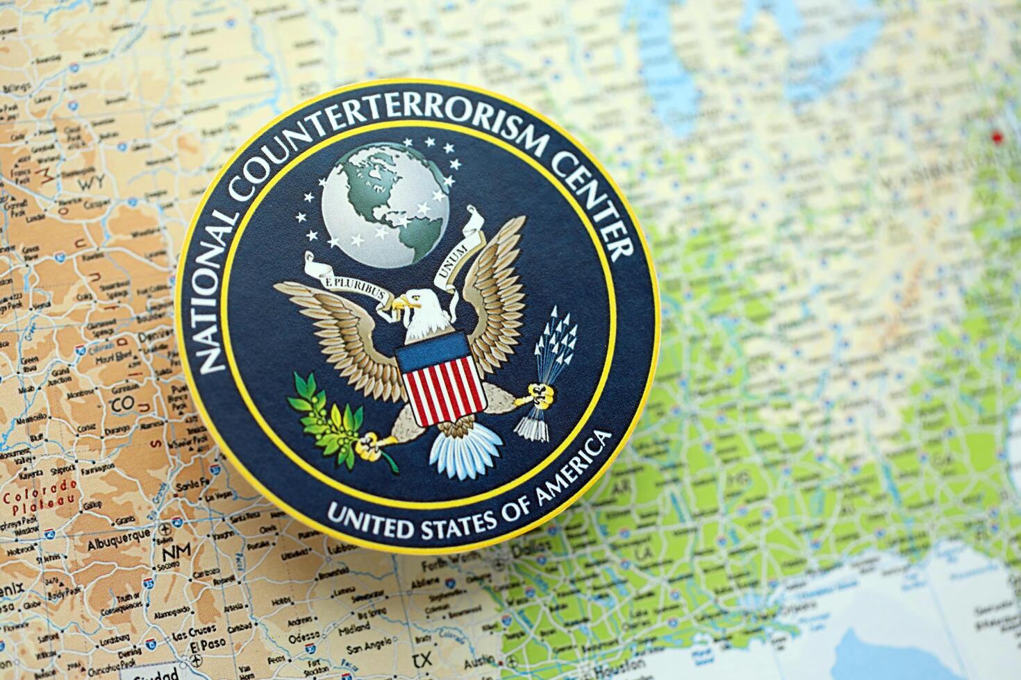 KYIV, UKRAINE - JUNE 26, 2024 United States National Counterterrorism Center coat of arms on paper map of United States photo