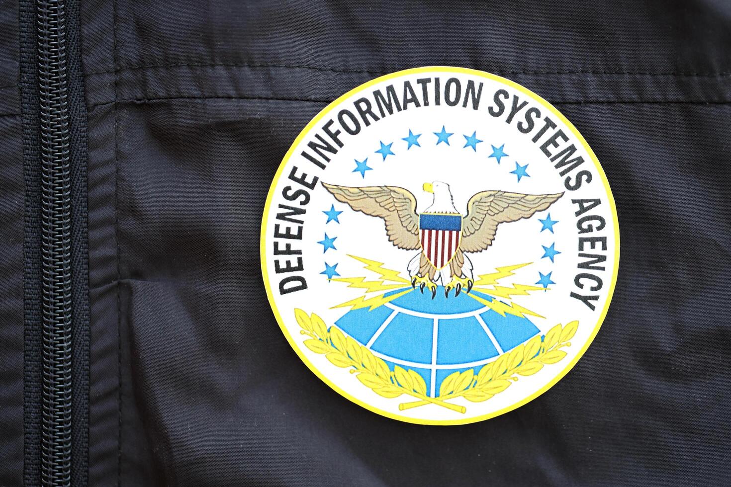 KYIV, UKRAINE - JUNE 26, 2024 Defense Information Systems Agency coat of arms as pin on black uniform jacket photo