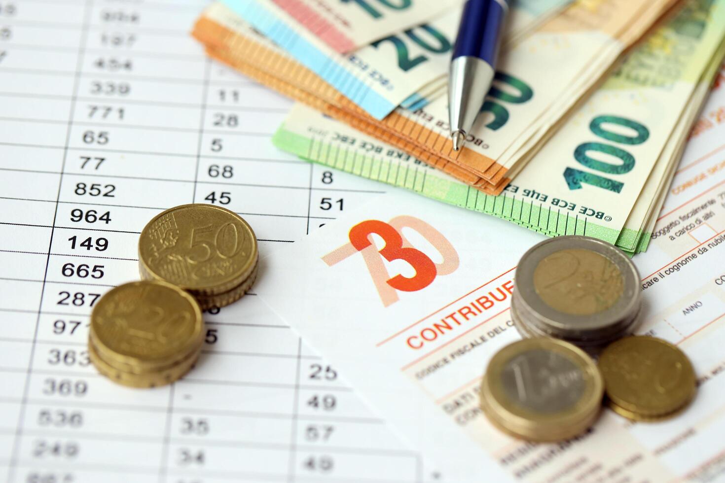 KYIV, UKRAINE - APRIL 20, 2024 many euro banknotes with the Modello 730 tax form as background, translating in Italian as declaration of incomes photo