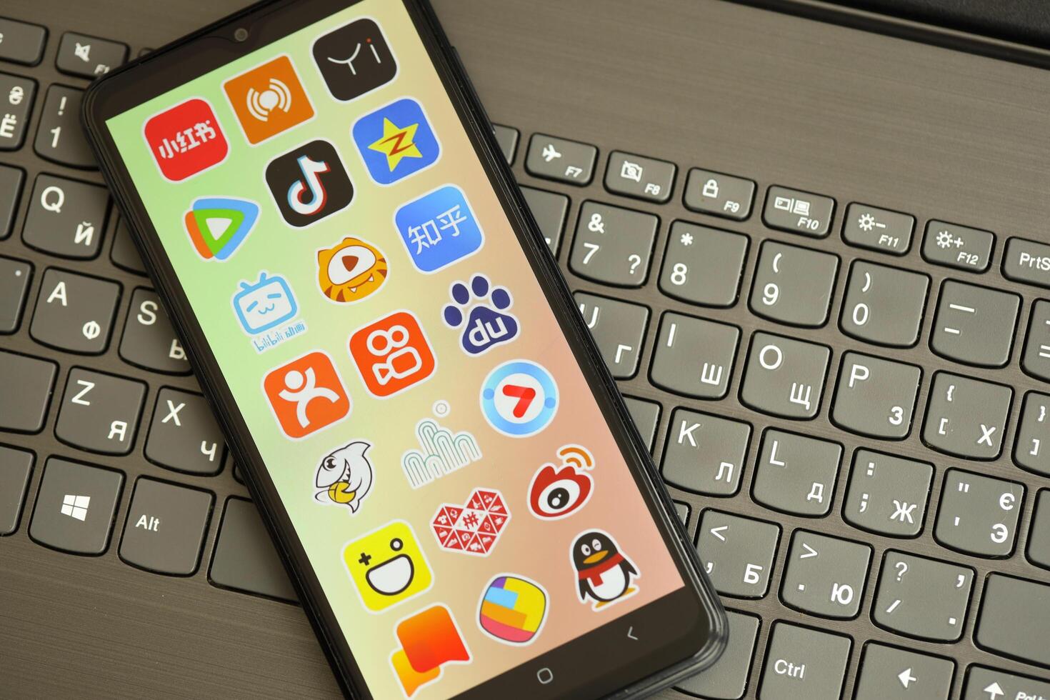 KYIV, UKRAINE - APRIL 1, 2024 Asian apps icon on smartphone screen on black keyboard photo