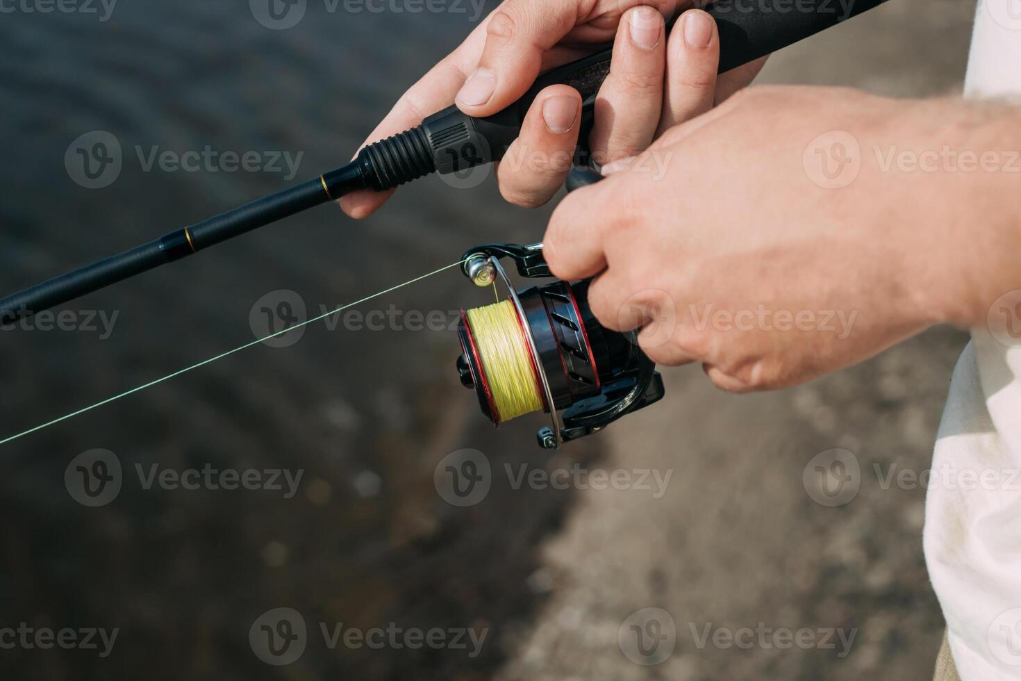 Fishing in river.A fisherman with a fishing rod on the river bank. Man fisherman catches a fish.Fishing, spinning reel, fish. The concept of a rural getaway. Article about fishing photo