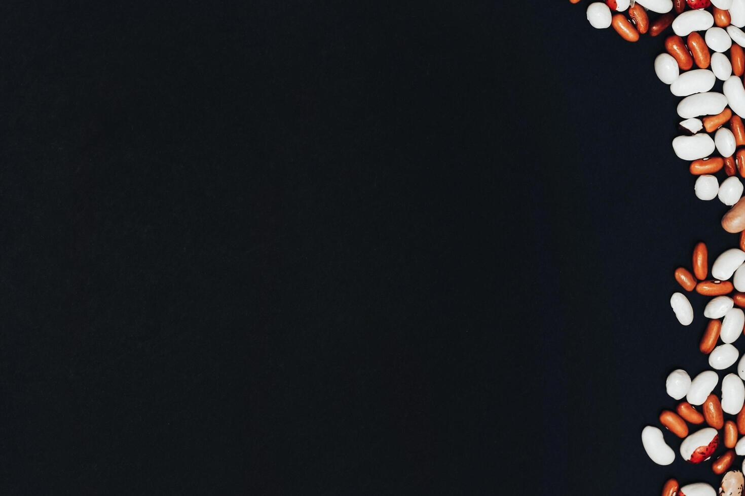 background with space for text. Multicolored beans on a black background photo