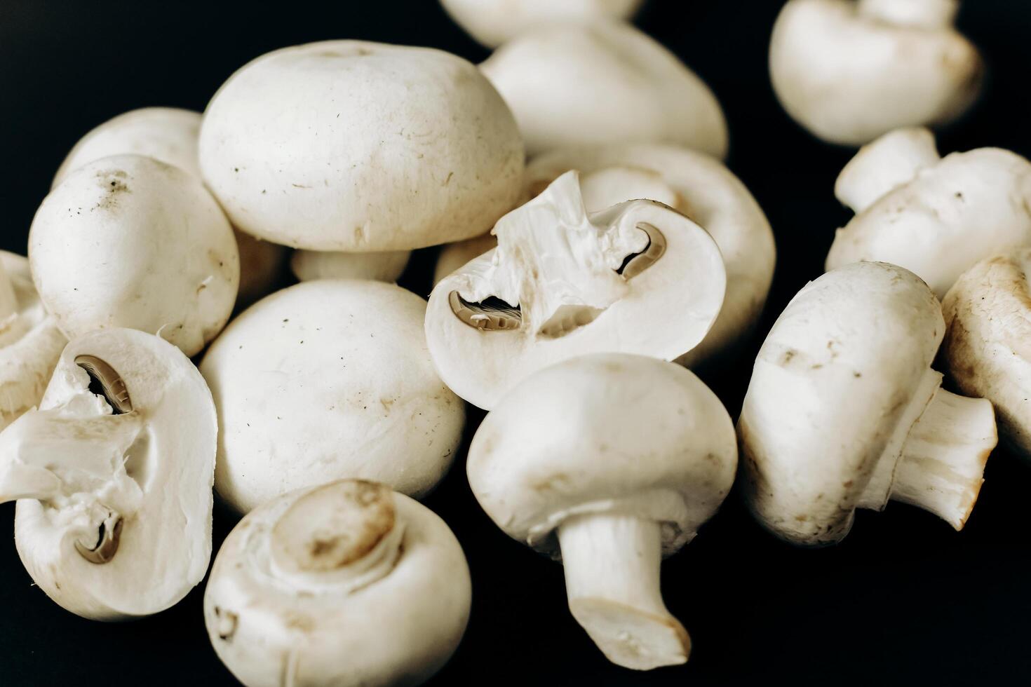 champignon mushrooms on a black background. space for text photo