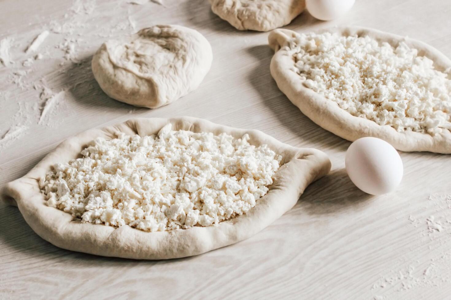 Homemade Ajarian Khachapuri with Suluguni Cheese Close Up. Stage of work. Raw Suluguni before baking photo
