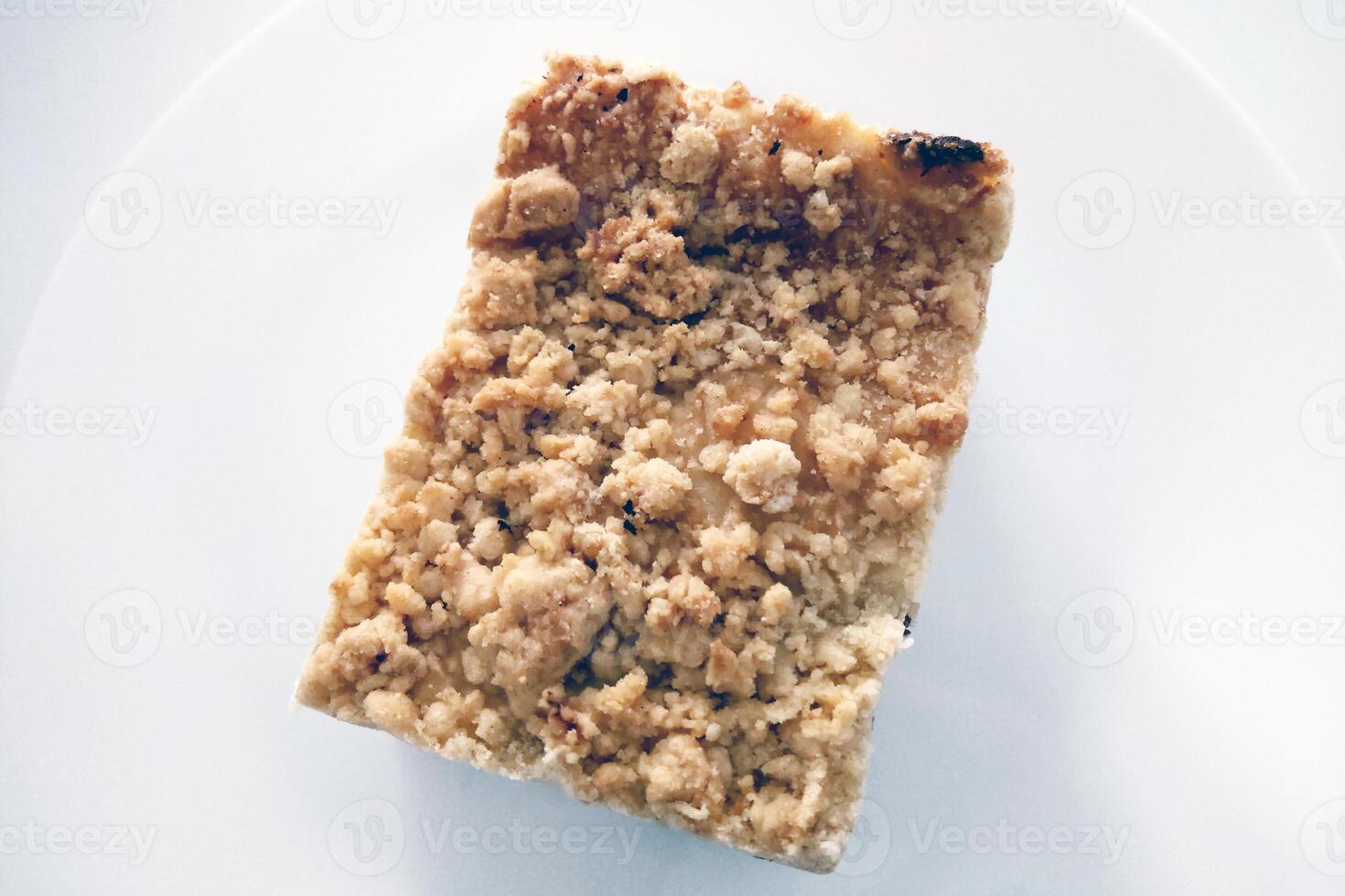 Close-Up of Delicious Crumble Cake Slice on White Plate Ideal for Bakery Designs, Menus, and Food Blogs photo