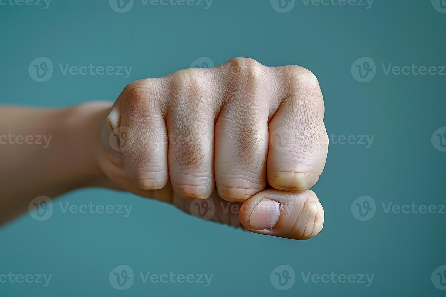 Clenched Fist Against Teal Background - Symbol of Strength and Determination for Motivational Posters and Designs photo
